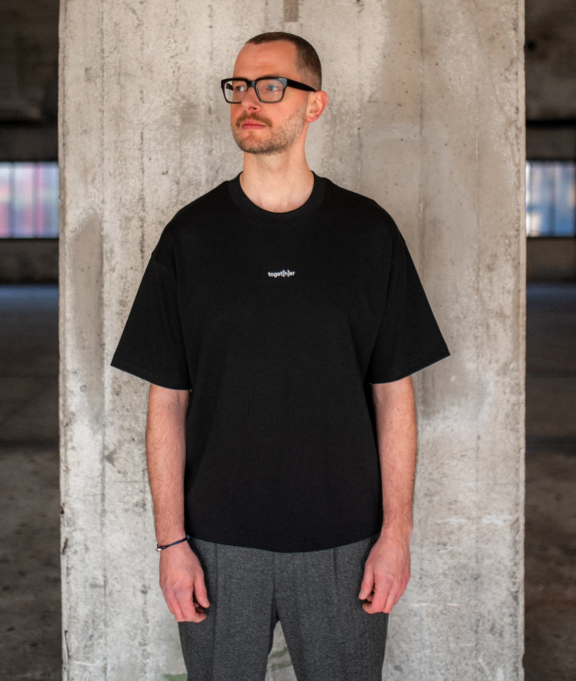 Person trägt schwarzes T-Shirt mit Schriftzug „toget[h]er“ auf der Brust