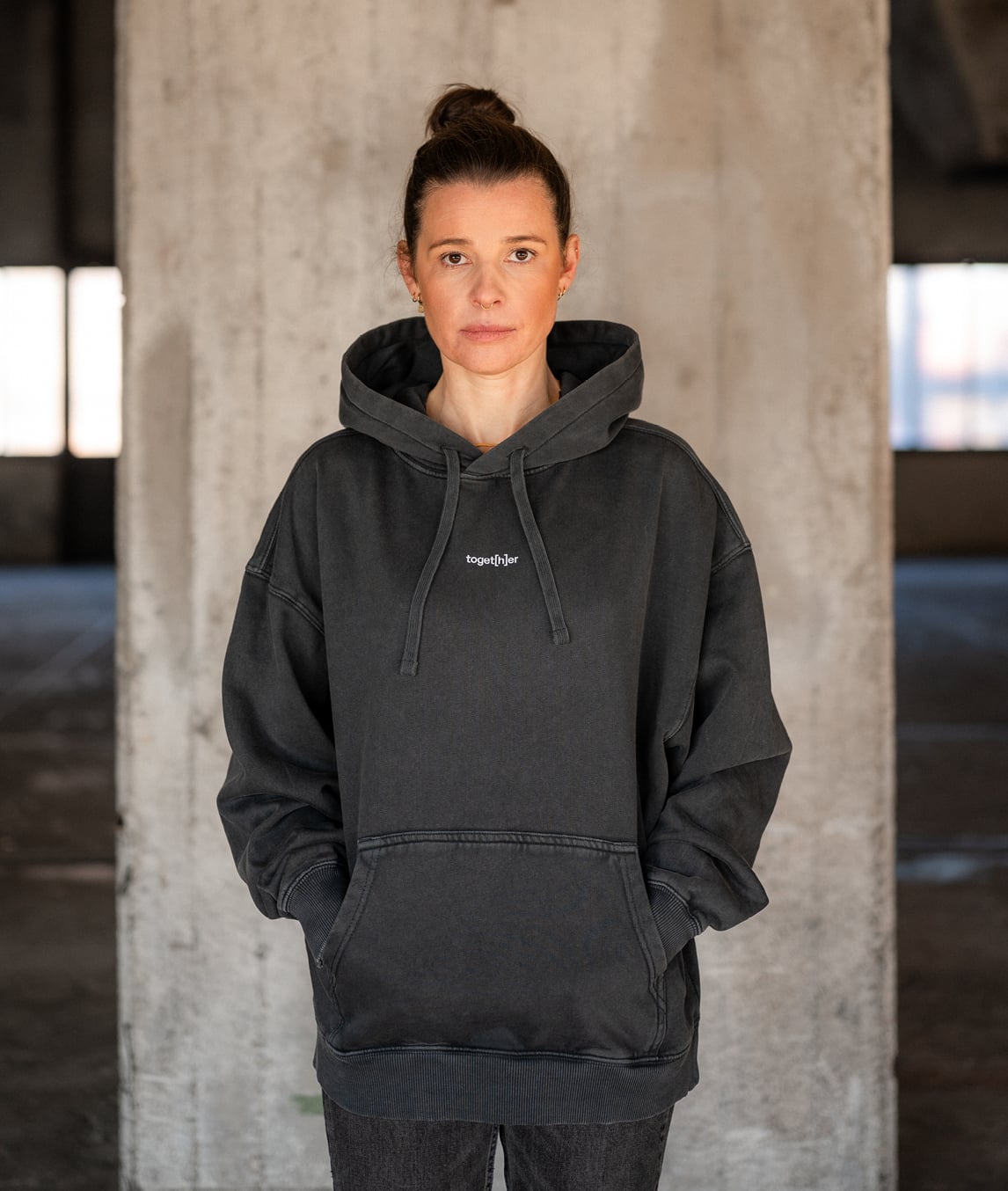 Frau trägt schwarzen Hoodie mit Schriftzug „toget[h]er“ auf der Brust