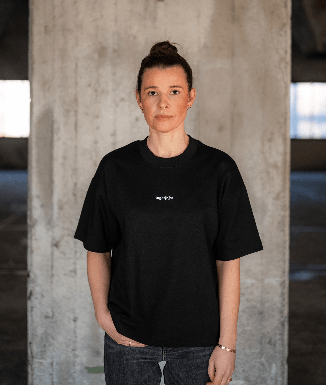 Person trägt schwarzes T-Shirt mit Schriftzug „toget[h]er“ auf der Brust