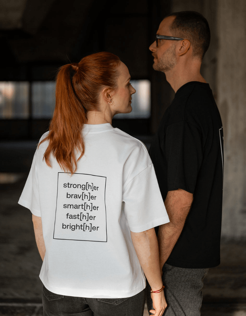 Person trägt helles T-Shirt mit einem typografischen Motiv auf dem Rücken