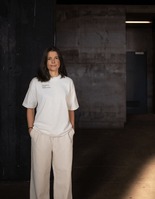 Person trägt helles T-Shirt mit einem Spruch auf der linken Brust